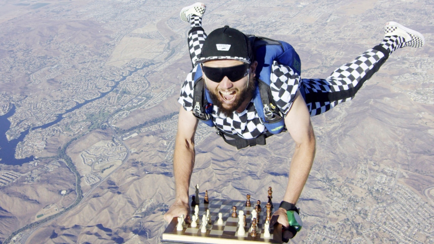Kỳ thủ cờ vua cố gắng giữ chặt bàn cờ khi nhảy dù từ độ cao hàng trăm mét