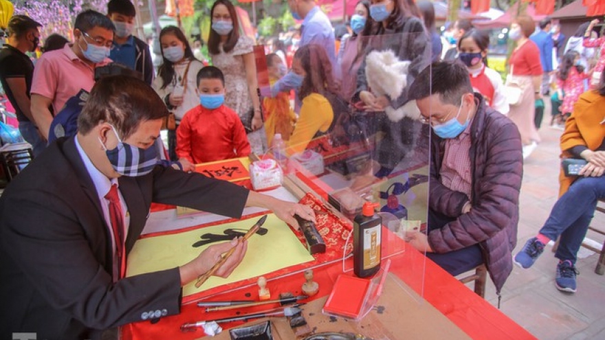 Calligraphers don face masks, give scripts on New Year's Day