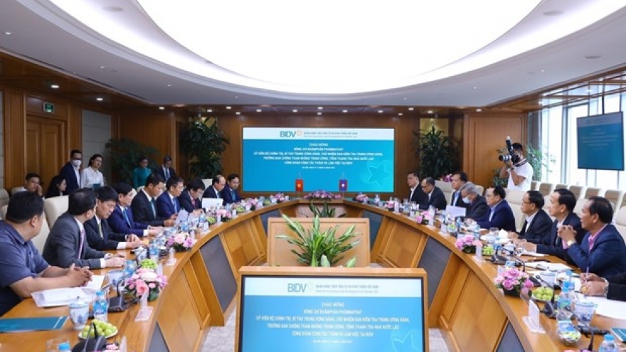 Lao official works with leaders of BIDV, EVN