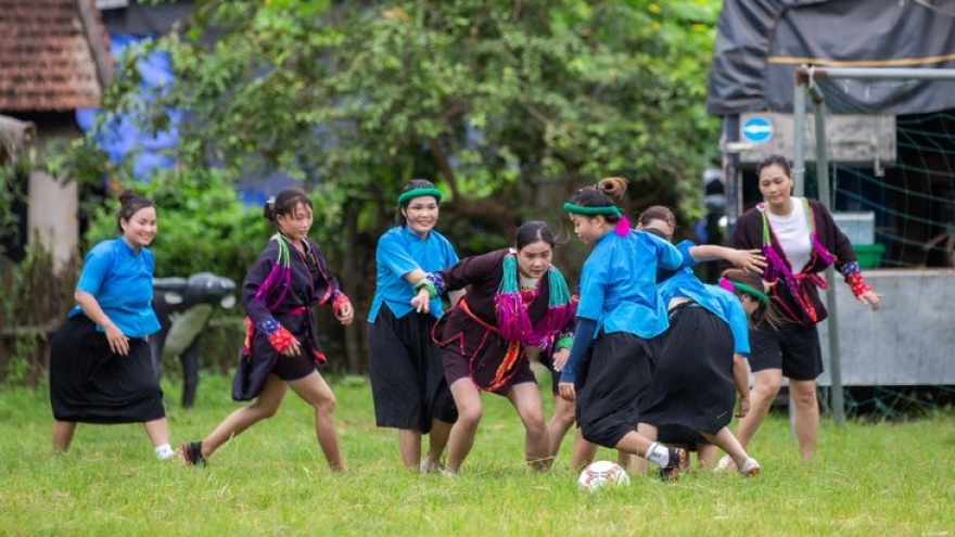 Ethnic women in skirts play football in mountainous market