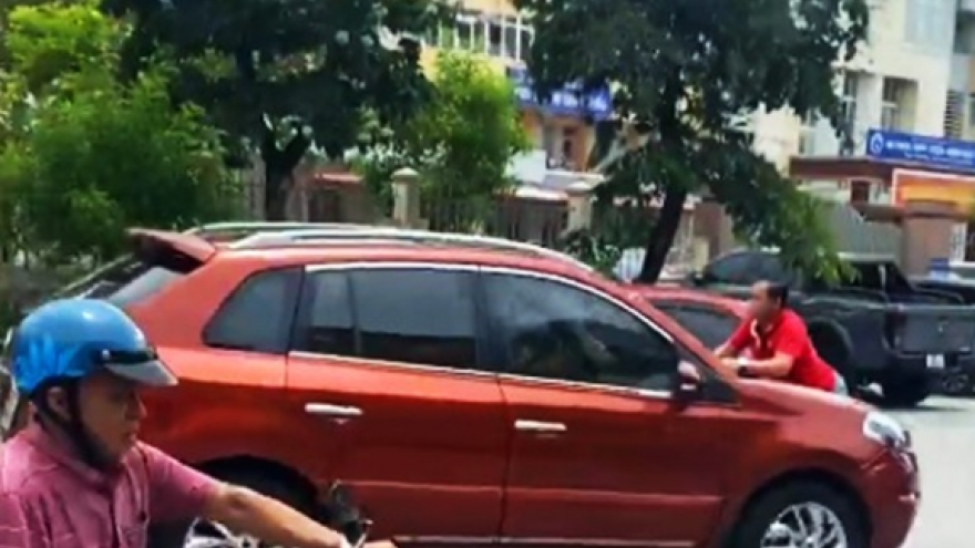 Người đàn ông bám nắp capo ô tô khi xe đang chạy