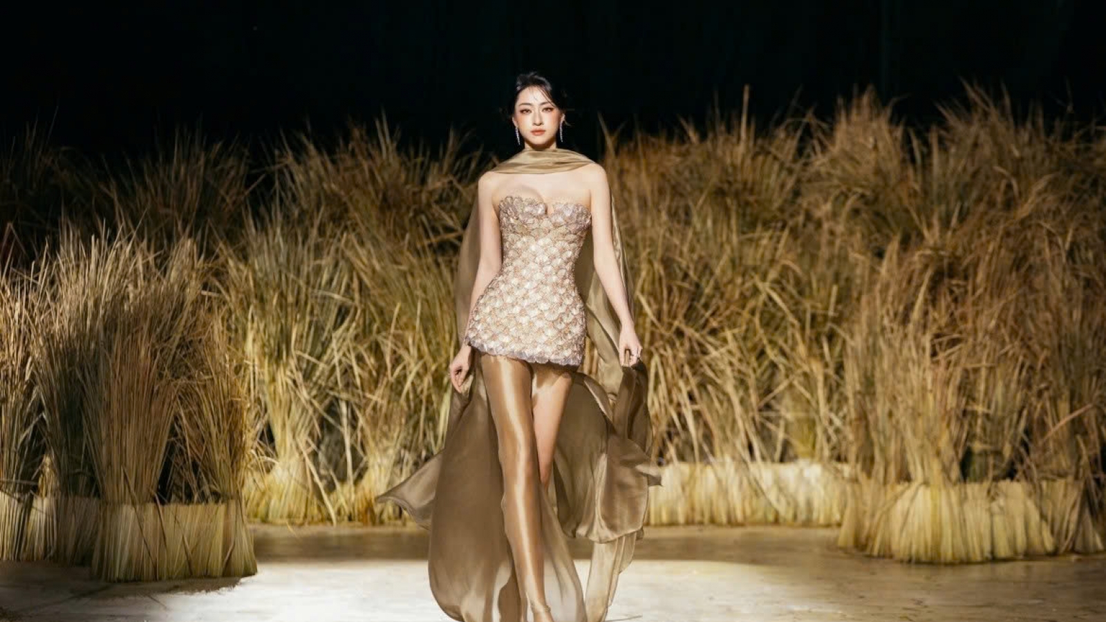 Vietnamese beauty queens walk runway covered with rice plants