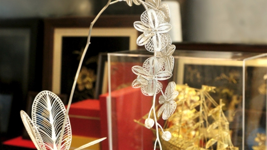 Gold-plated orchid, apricot, and peach tree models attract customers for Tet