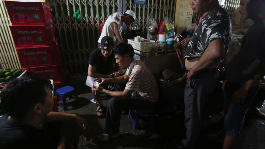 Long Bien Market traders watch World Cup while on the go