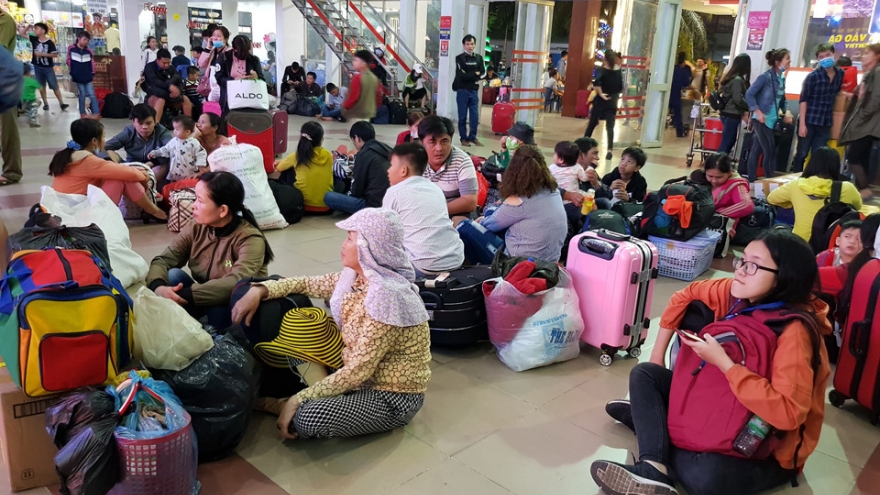People cram into trains on the long journey home for Tet