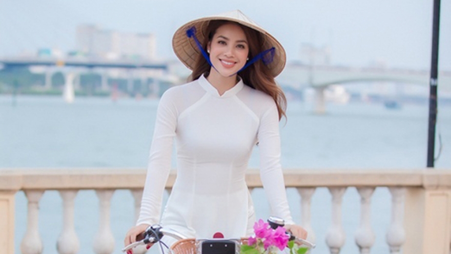 
        Pham Huong cycles the Danang streets in a white Ao Dai 
                          
                      