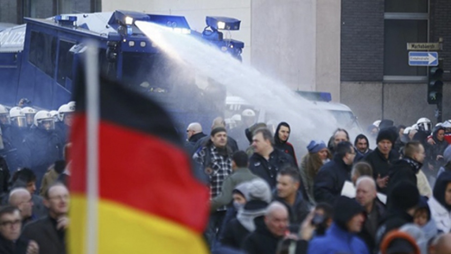 German police spray anti-migrant protesters, Merkel toughens tone