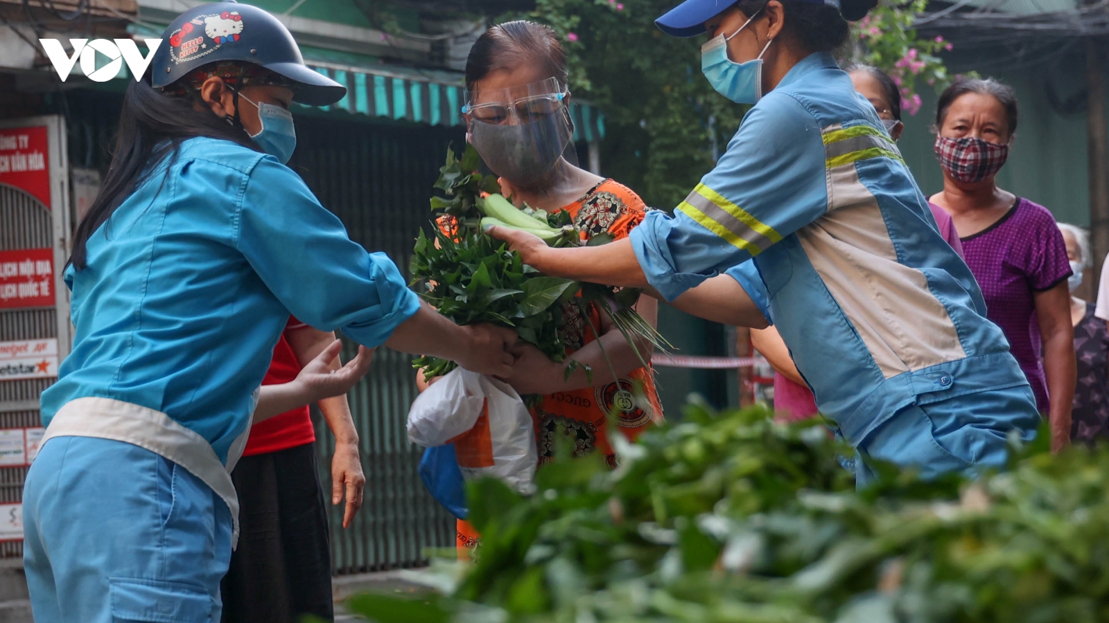 Nữ lao công vừa quét rác vừa phát rau miễn phí cho người gặp khó khăn vì dịch Covid-19