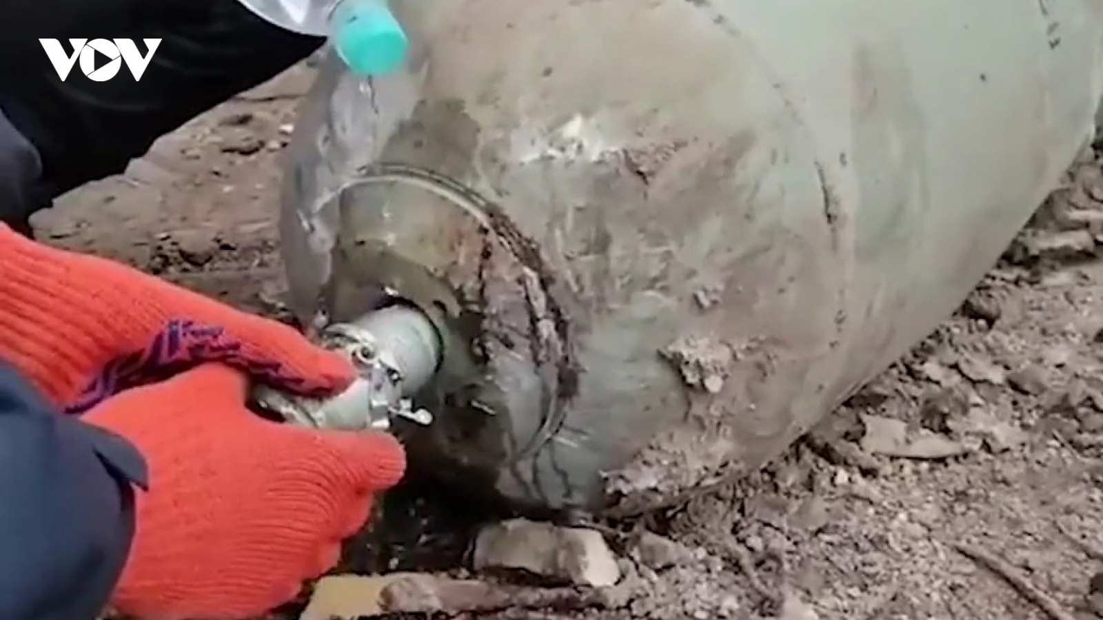 Nam thanh niên Ukraine tháo ngòi quả bom bằng 2 tay và chai nước