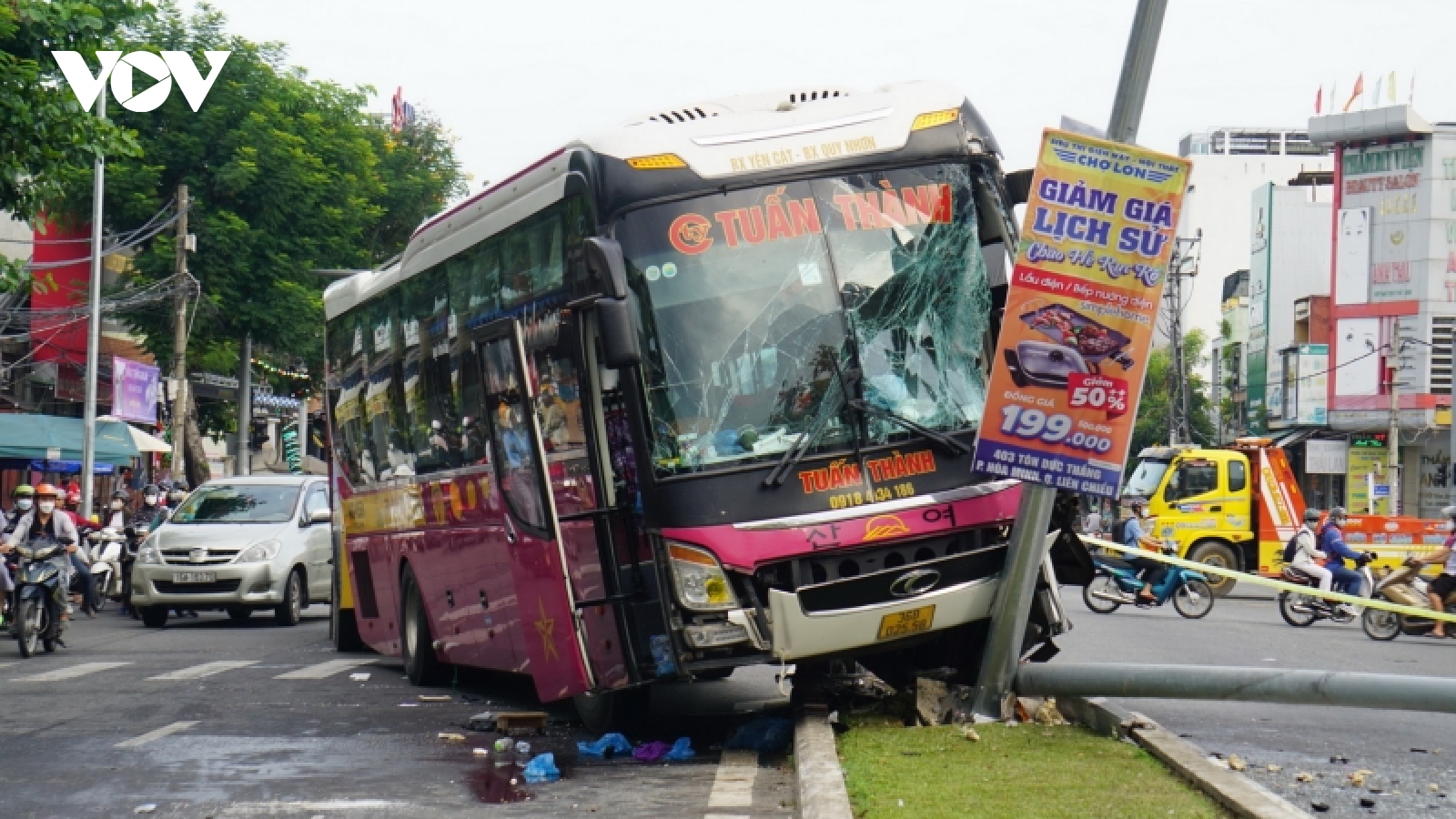 Tránh xe đạp, ô tô khách leo dải phân cách đâm gãy 2 trụ điện chiếu sáng