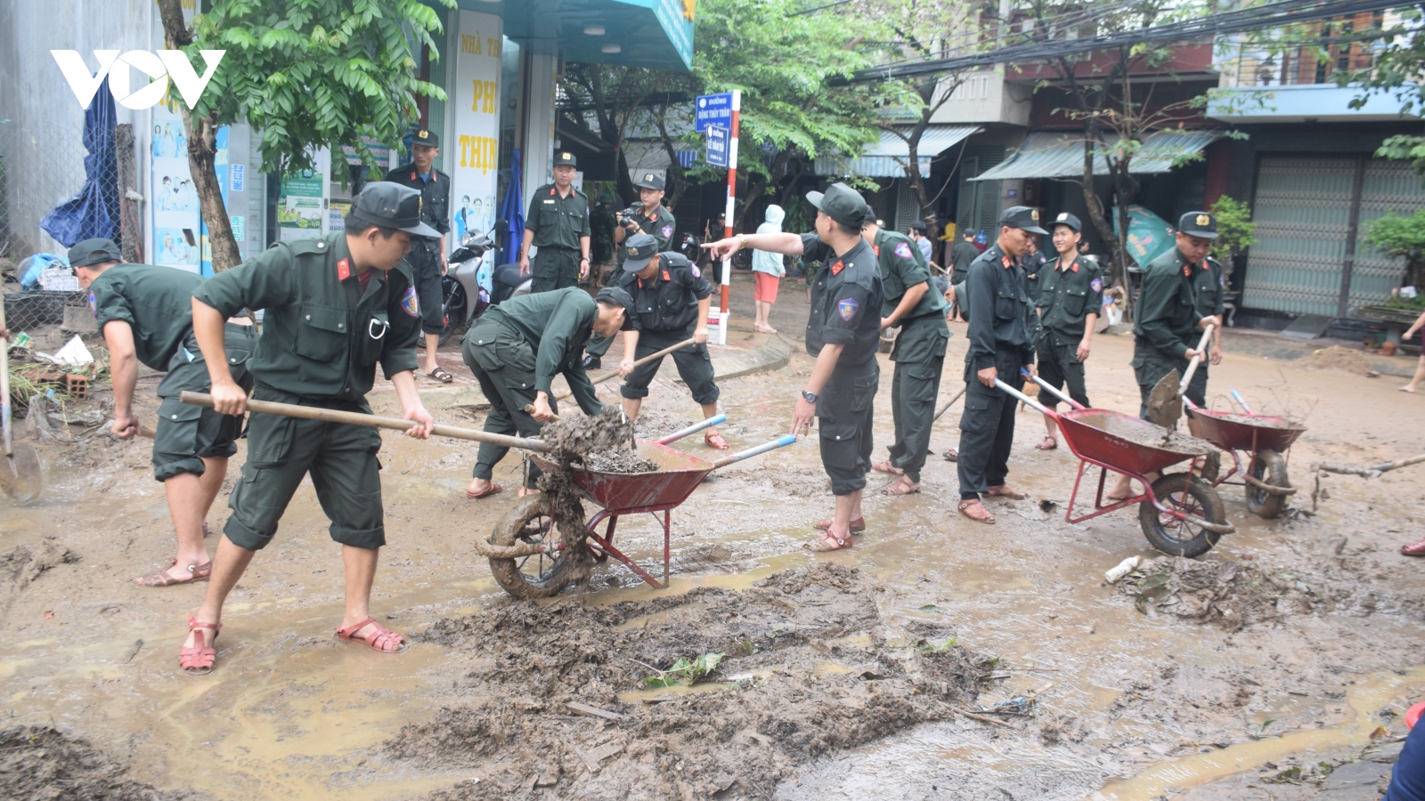 Bộ đội, công an giúp người dân dọn nhà cửa sau lũ