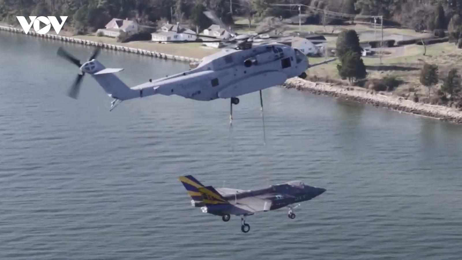 Trực thăng quân sự CH-53K cẩu tiêm kích F-35C bay qua biển