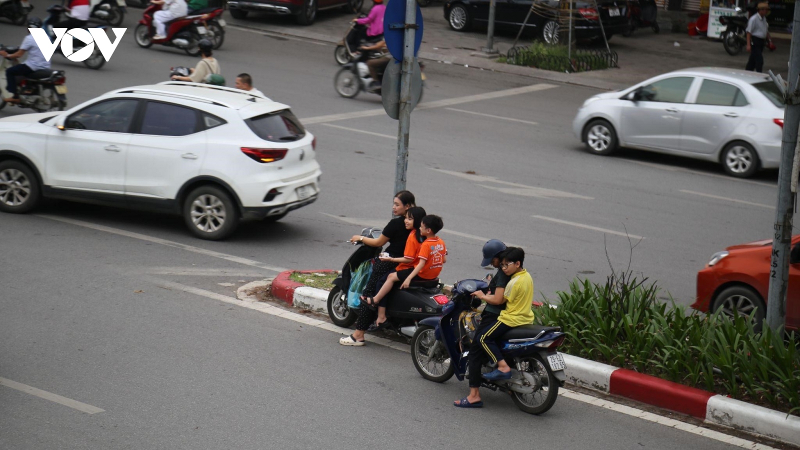 Phụ huynh không đội mũ bảo hiểm, chạy xe ngược chiều đón con tan học ở Hà Nội