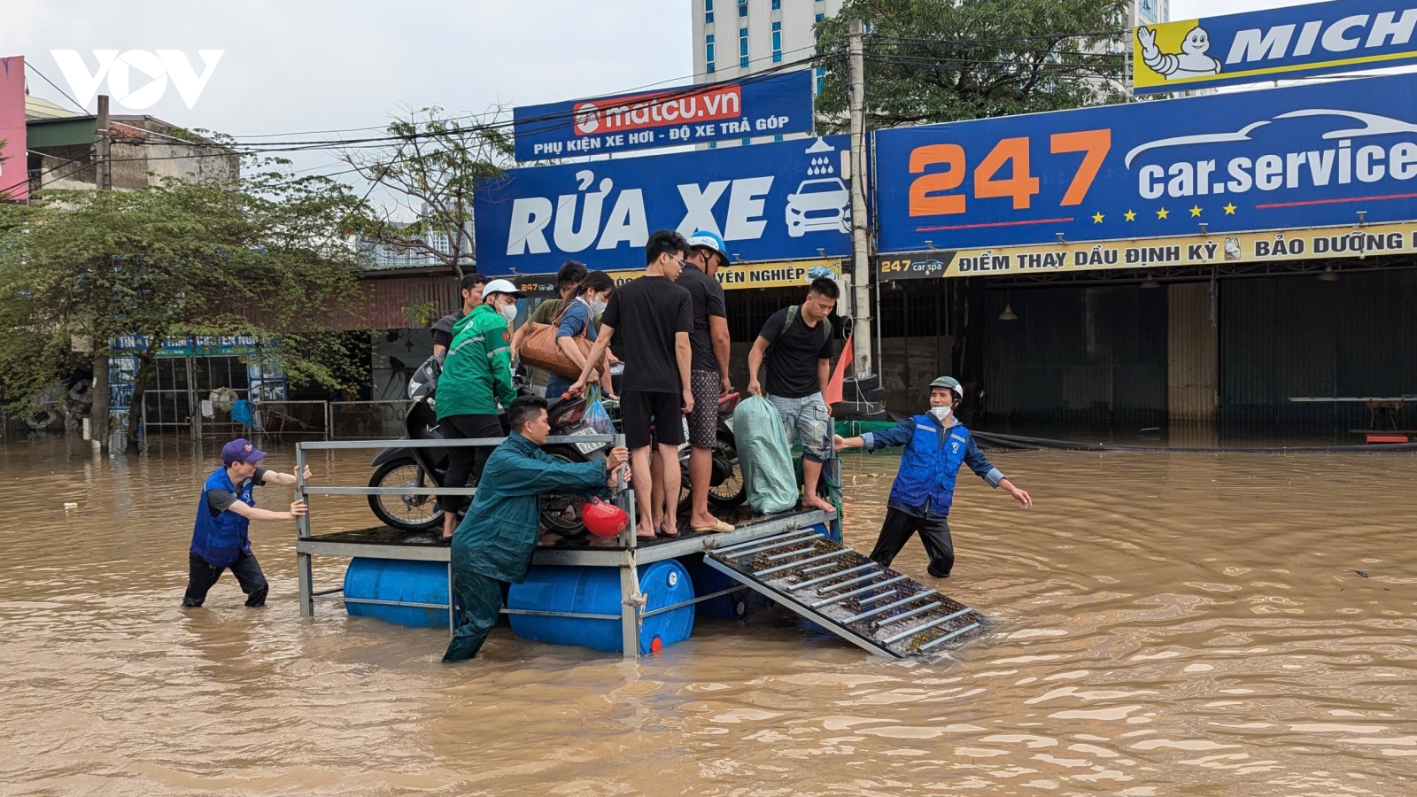 Dân quân tự vệ dùng phà tự chế đưa người dân qua đoạn đường ngập sâu ở Hà Nội