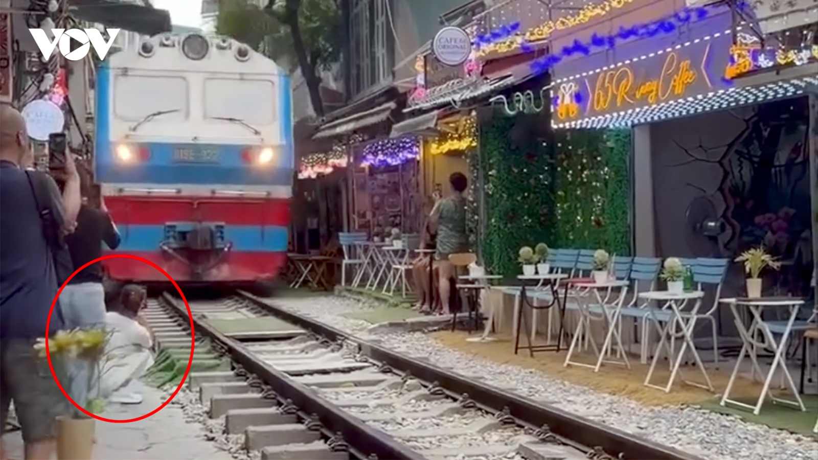 Cô gái ngồi cà phê đường tàu bị tàu hỏa hất văng điện thoại, suýt cuốn vào gầm