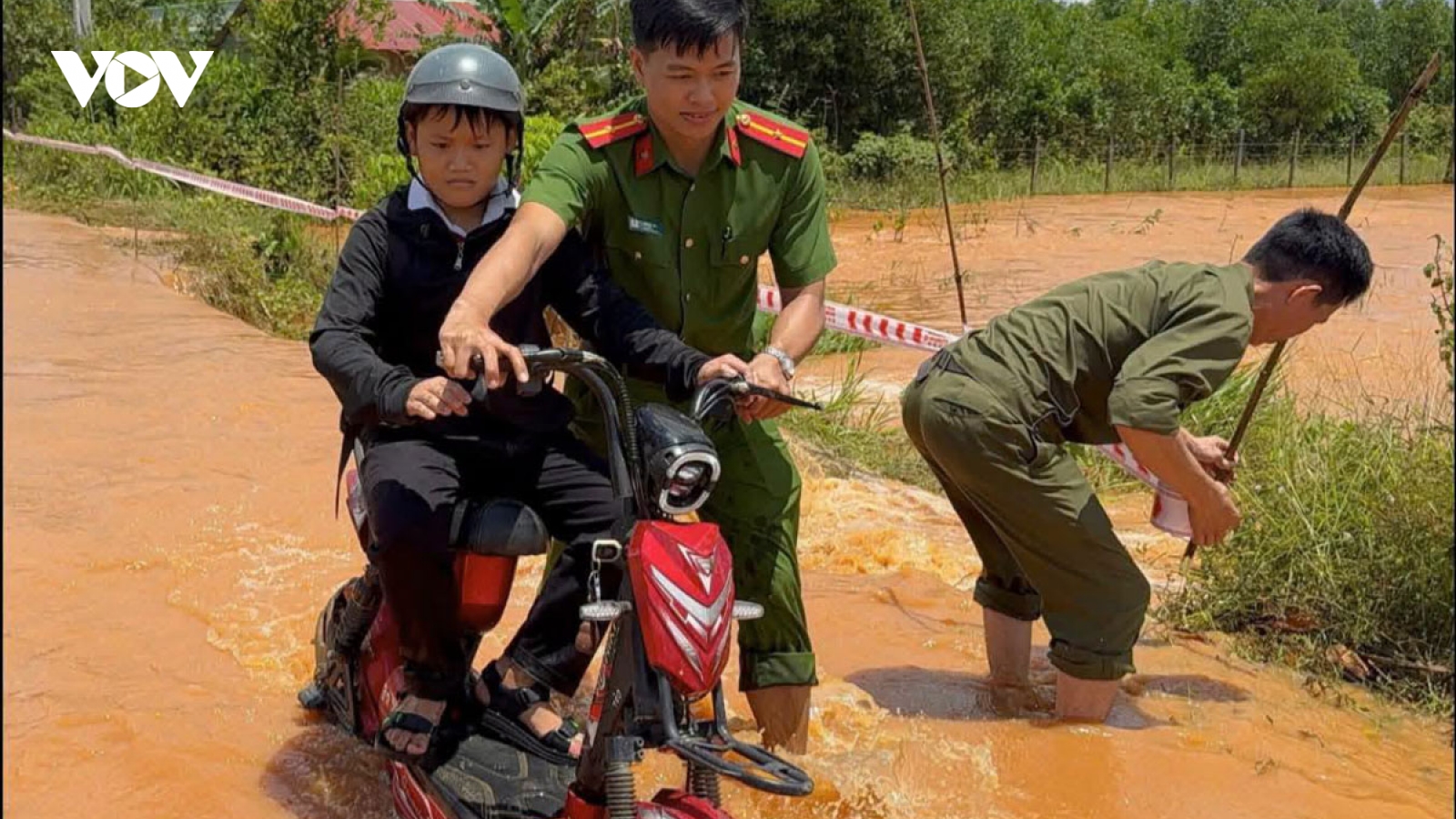 Công an xã ở Đồng Nai giăng dây cảnh báo, hỗ trợ học sinh qua vùng ngập sâu