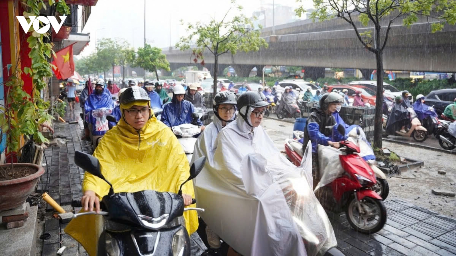 Commuters wade through flooded streets as torrential rain lashes Hanoi