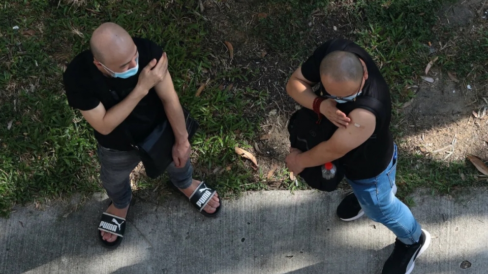 Singapore tiem chung Covid, 2 nam gioi ben ngoai co so y te sau tiem, -NurPhoto.jpg