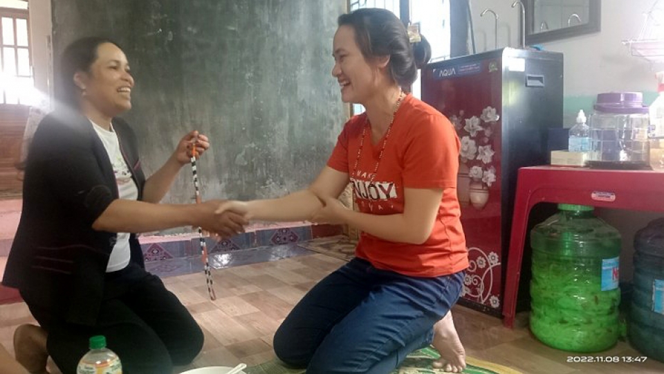 A K'Ho woman gives a strings of beads to her guest..jpg