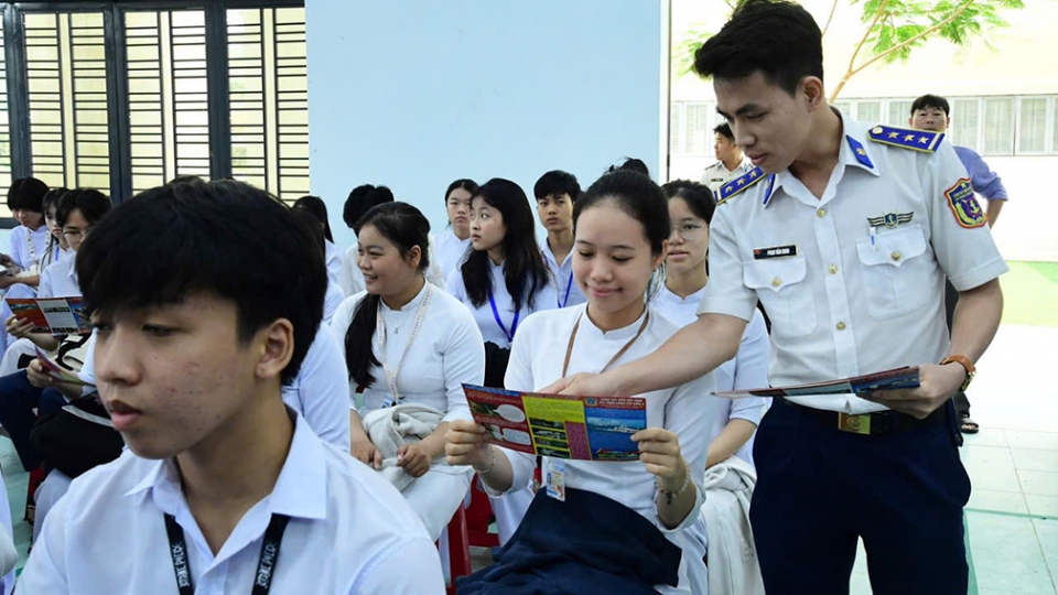 Cán bộ Cảnh sát biển tuyên truyền, phổ biến pháp luật bằng tờ rơi cho học sinh.jpg