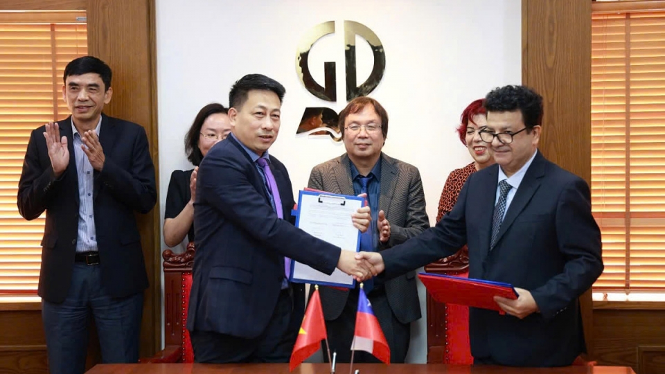 Representatives from the Vietnam Education Publishing House and the Chilean Embassy exchange the signed coopertion document.jpg