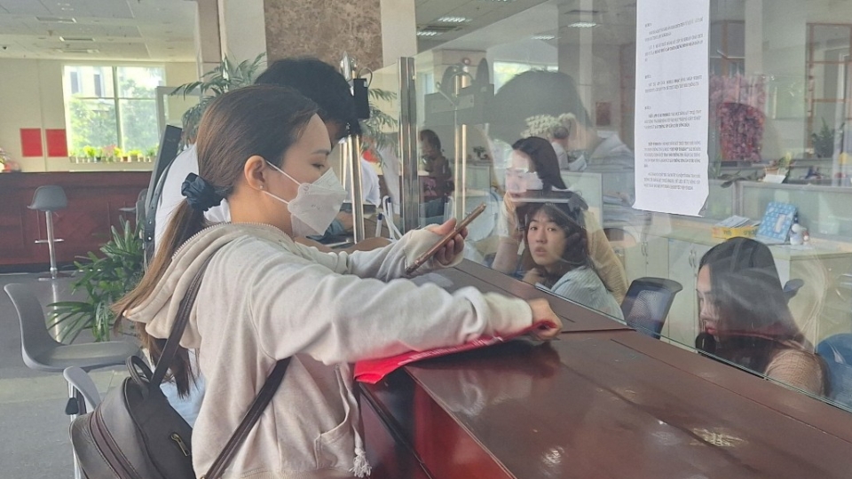 Cán bộ thuế đang hướng dẫn thủ tục cho người nộp thuế.png