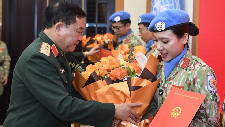 Sen. Lieut. Gen. Hoang Xuan Chien hands over the State President's decisions to the officers.jpg
