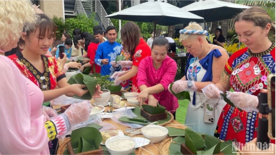 Foreign visitors excitedly join Tet cake wrapping contest