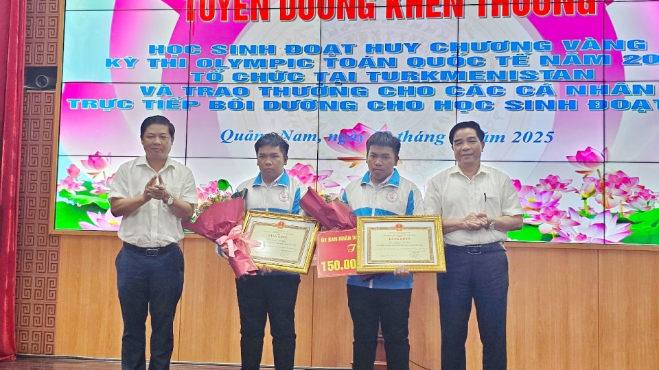 Ông Lương Nguyễn Minh Triết, Bí thư Tỉnh uỷ Quảng Nam (bên trái) và ông Lê Văn Dũng, Chủ tịch UBND tỉnh Quảng Nam trao bằng khen và tặng hoa 2 học sinh..jpg