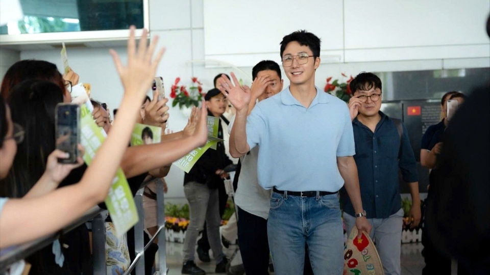 Korean actor Jung Il Woo, in simple but elegant outfit, waves at Vietnamese fans at Tan Son Nhat Airport.jpg