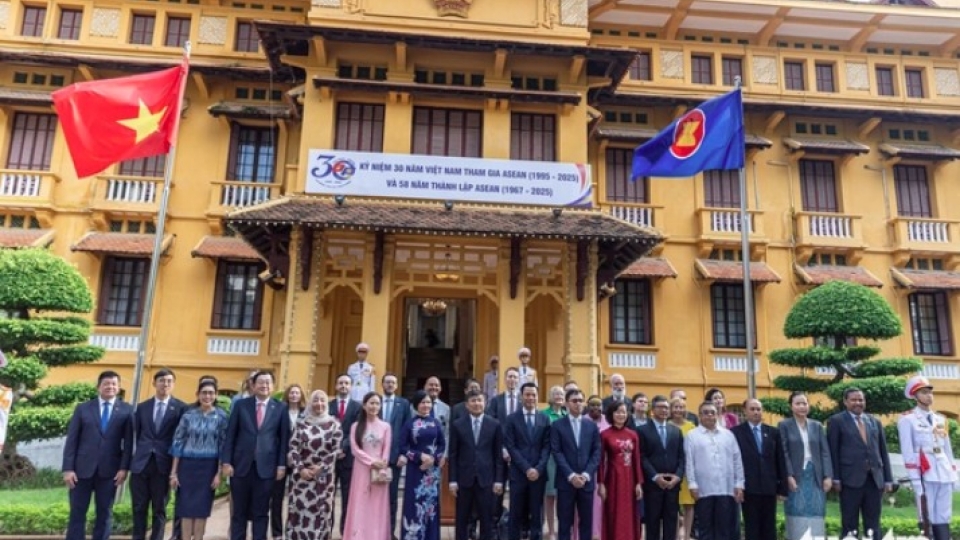 Delegates pose for a group photo at a flag-hoisting ceremony marking ASEAN’s 58th anniversary.jpg