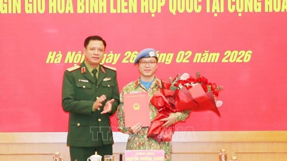 Senior Lieutenant General Nguyen Truong Thang, Deputy Minister of National Defence, presents the decision to Lieutenant Colonel Nguyen Hoang Long.jpg