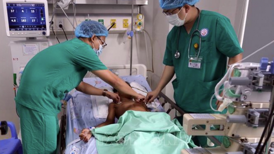 Doctors check the health of two pediatric patients receiving treatment at Da Nang Hospital for Women and Children.jpg