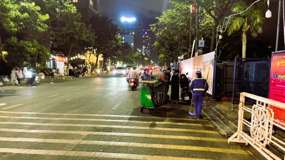 Công nhân môi trường thu gom rác thải tại khu vực khán đài sau đêm thi pháo hóa.jpg