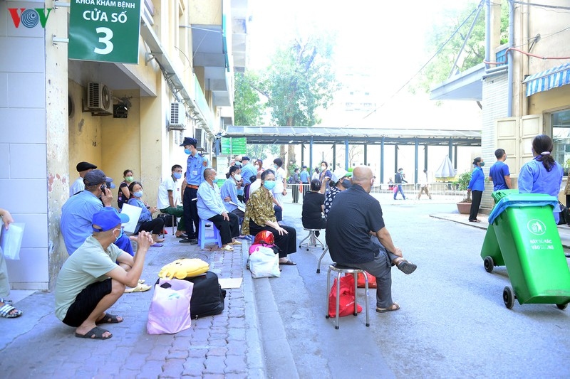 Trong lúc làm các thủ tục vào bên trong viện, nhiều người ngồi vạ vật trước cổng bệnh viện Bạch Mai.