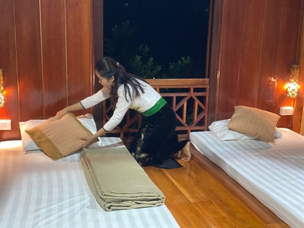 Luong Thi Hong Tuoi, of the Thai ethnic minority group in Vat village, Muong Sang commune, Moc Chau district in the northern province of Son La, tidies up a room in her homestay. She received support from the GREAT programme to open the service.