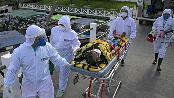 Nhân viên y tế chuyển bệnh nhân mắc Covid-19 tới bệnh viện ở Breves, Brazil. Ảnh: AFP/TTXVN)