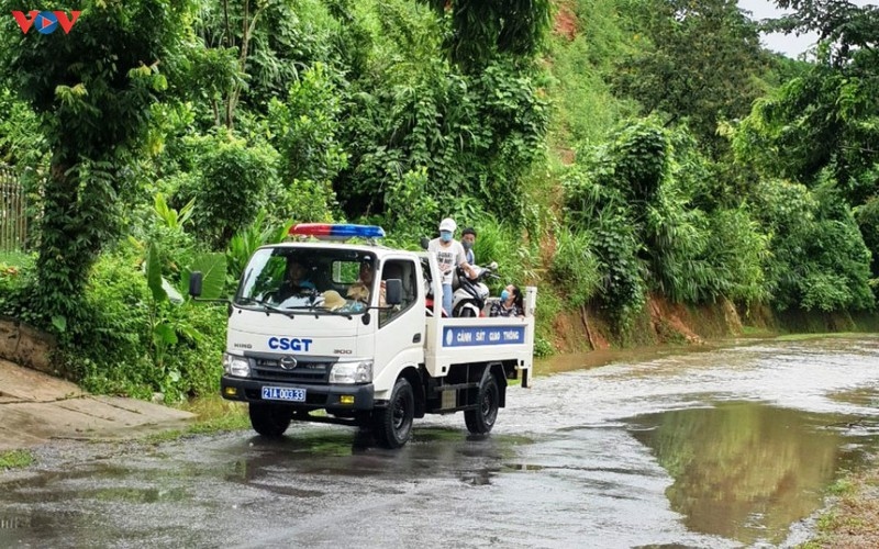 Lực lượng CSGT dùng xe chuyên dụng đưa người dân qua khu ngập nước.