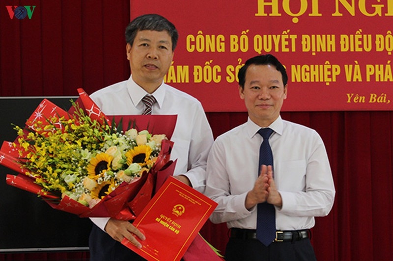 Chủ tịch UBND tỉnh Yên Bái ông Đỗ Đức Duy (bên phải) trao Quyết định và tặng hoa chúc mừng ông Đinh Đăng Luận