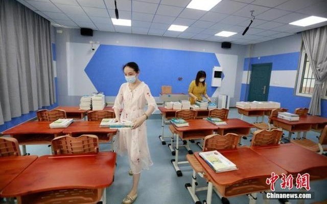 Các cô giáo chuẩn bị sách giáo khóa mới cho học sinh tại một trường học ở Vũ Hán. Ảnh: Chinanews.