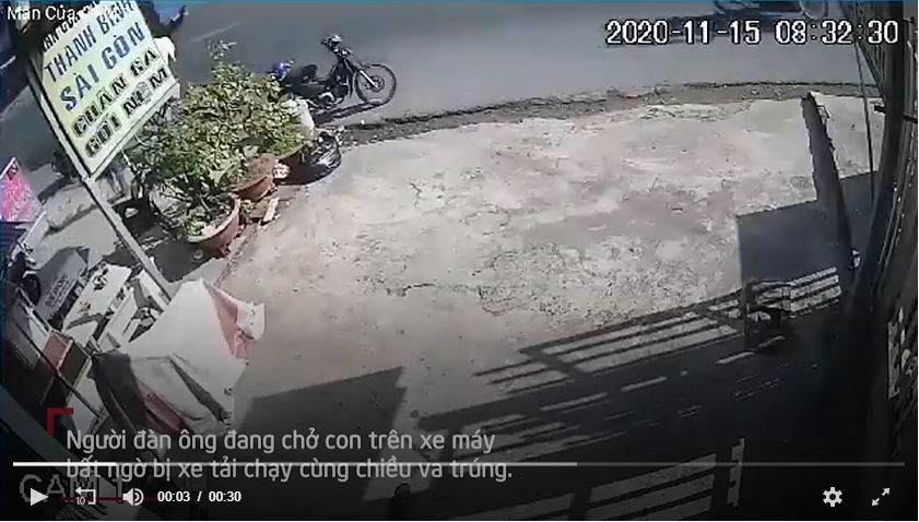 Ngã ngay bánh xe tải, hai cha con may mắn thoát chết