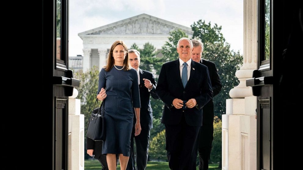 Thẩm phán Amy Coney Barrett và Phó Tổng thống Mike Pence bước lên các bậc thang của Điện Capitol để gặp các thượng nghị sĩ ở Washington vào ngày 29/9. Ông Trump đề cử bà Amy Coney Barrett thay thế cho cố thẩm phán Ruth Bader Ginsburg. Ảnh: Reuters