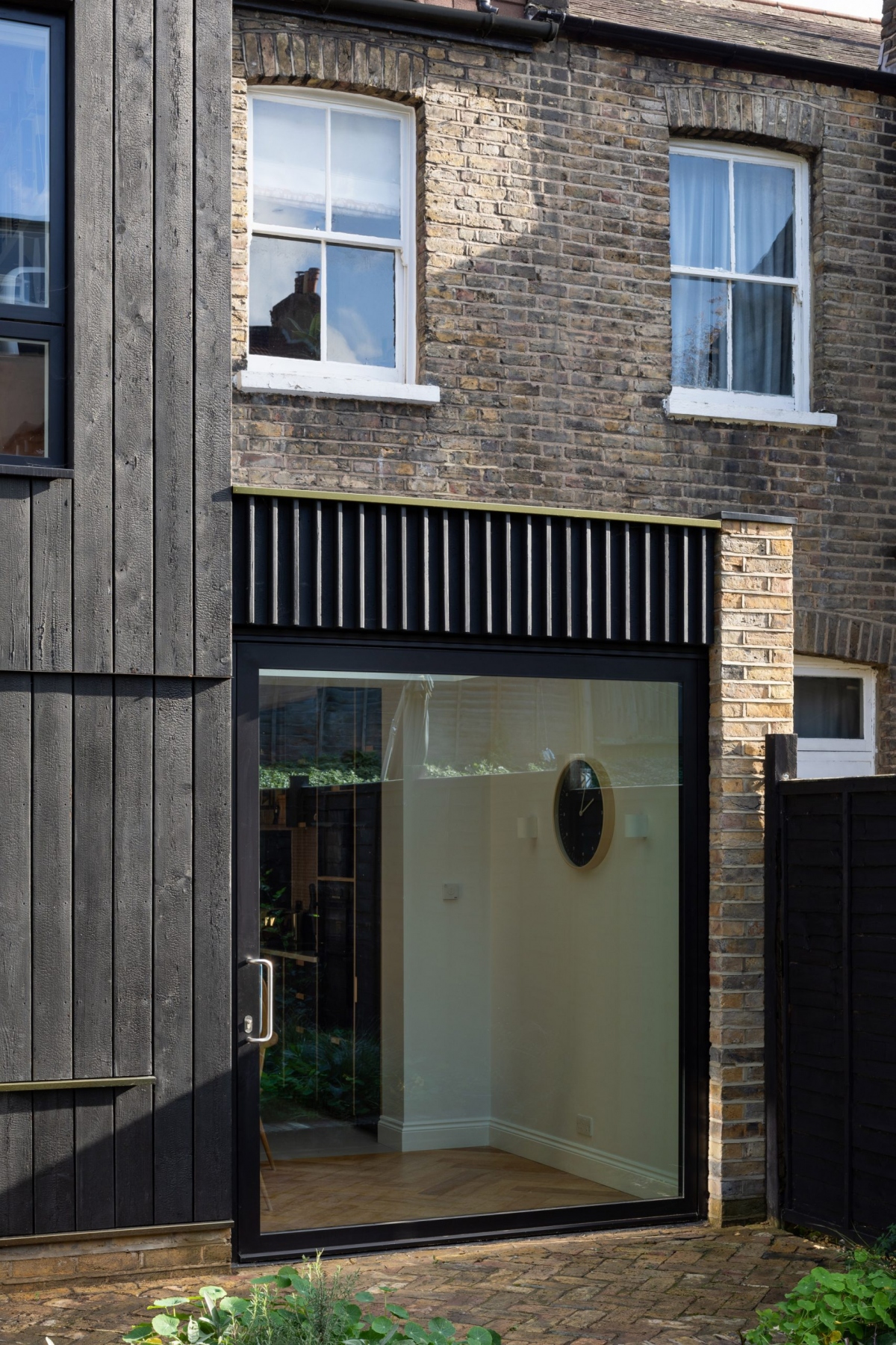 Cửa kính đen hiện đại kết hợp đồng điệu cùng kiến trúc cổ điển của căn nhà.