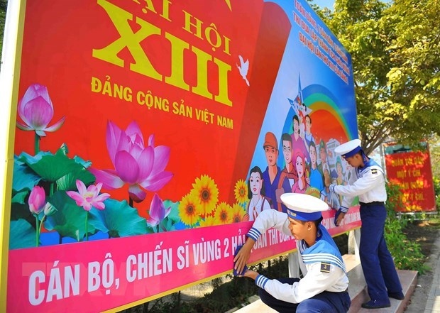 Naval soldiers hang on a poster to welcome the 13th National Party Congress (Photo: VNA)