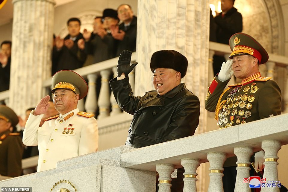 Từ trên lễ đài, nhà lãnh đạo Kim Jong Un (mặc áo da và đội mũ ấm) tươi cười vẫy tay chào binh sĩ và nhân dân Triều Tiên. Ông Kim vừa được bầu làm Tổng bí thư Đảng Lao động Triều Tiên trong Đại hội 8 của đảng này.