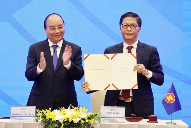Prime Minister Nguyen Xuan Phuc (L), as Chair of ASEAN in 2020, witnesses the signing of the Regional Comprehensive Economic Partnership (RCEP) agreement