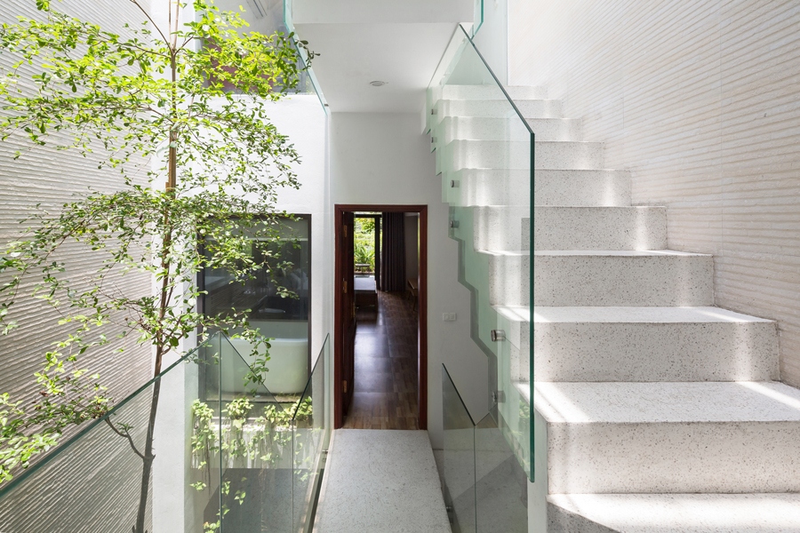 Cầu thang đơn giản với lan can kính tạo sự thông thoáng, bậc trát đá granito màu sáng cho cảm giác nhẹ nhàng.