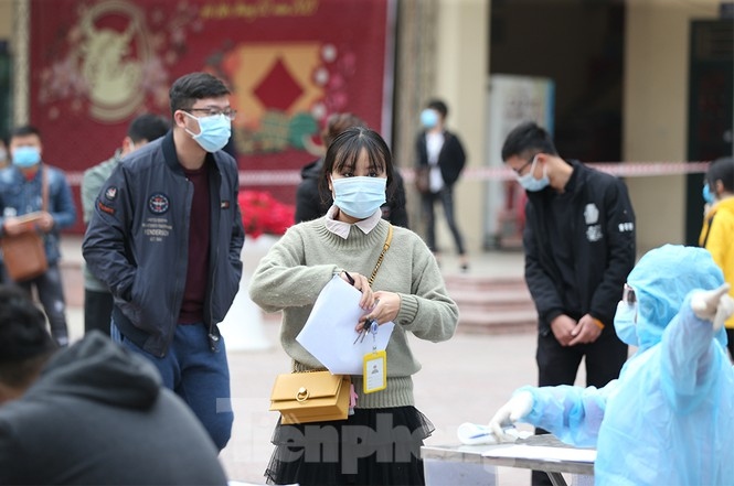People returning from COVID-19 hotspots nationwide gather at Phan Huy Chu high school in Dong Da district of Hanoi to have samples taken for the quick test.