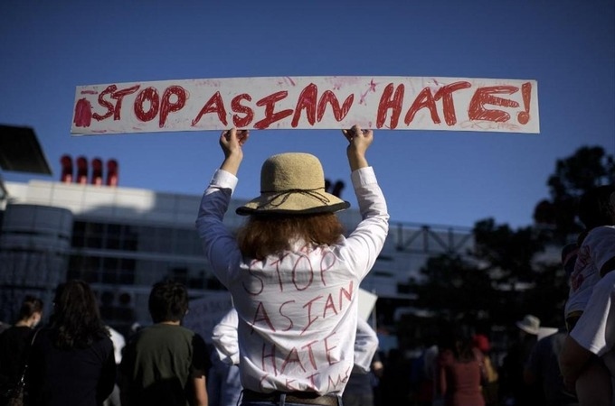 Một người biểu tình mặc áo và giơ biểu ngữ có dòng chữ "ngừng thù ghét người gốc Á" tại Texas ngày 21/3. Ảnh: AFP.