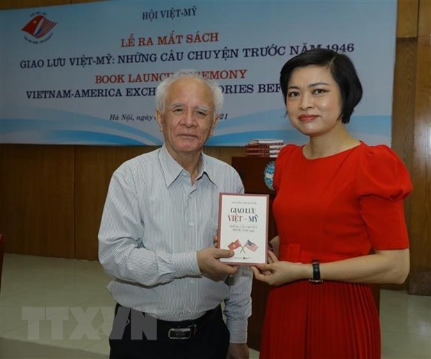 Nguyen Van Huynh (L) presents his book, titled "Vietnam-America exchanges: Stories before 1946" to a guest at the book launch